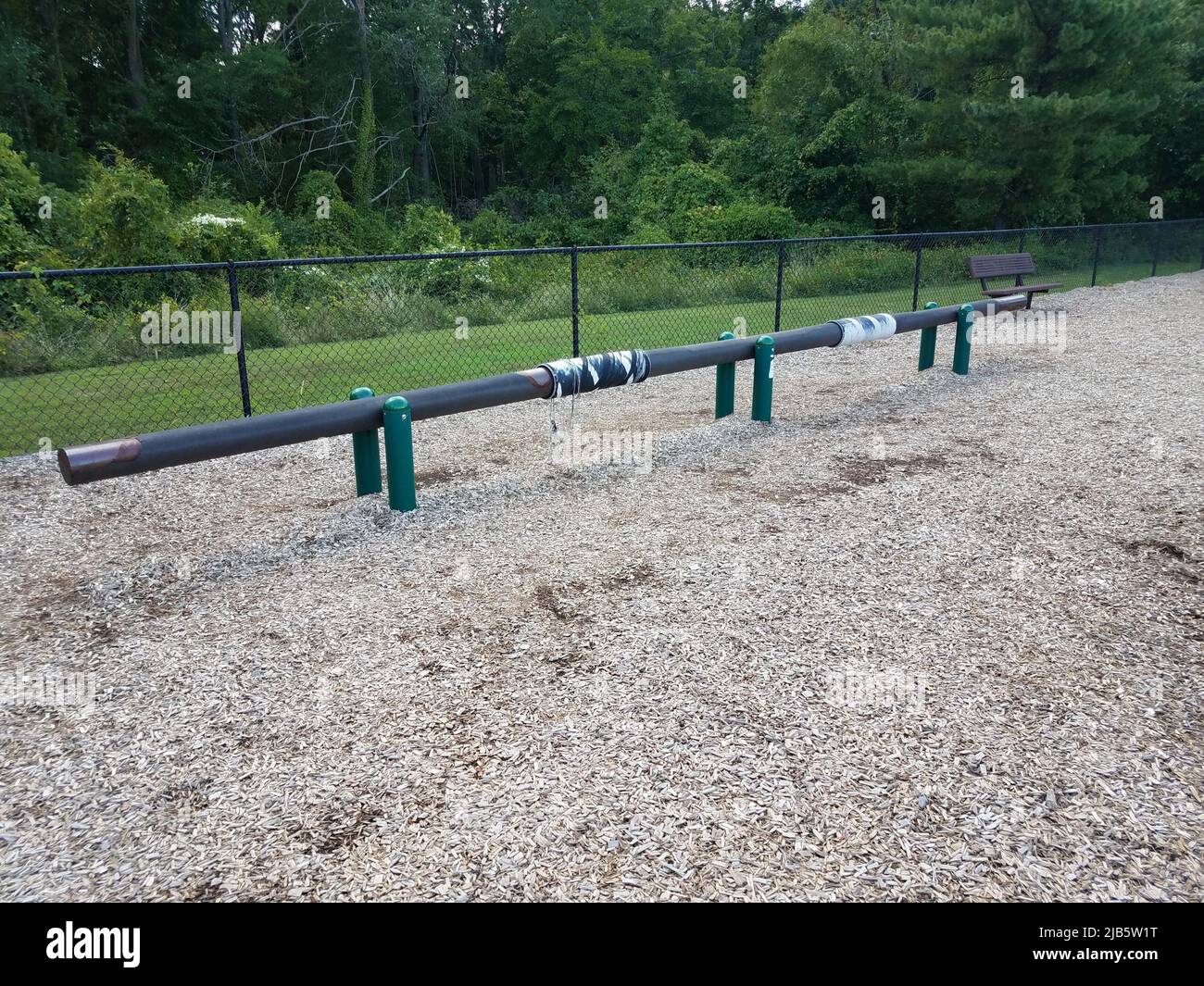 long balance beam at playground or park with brown wood chips. Stock Photo