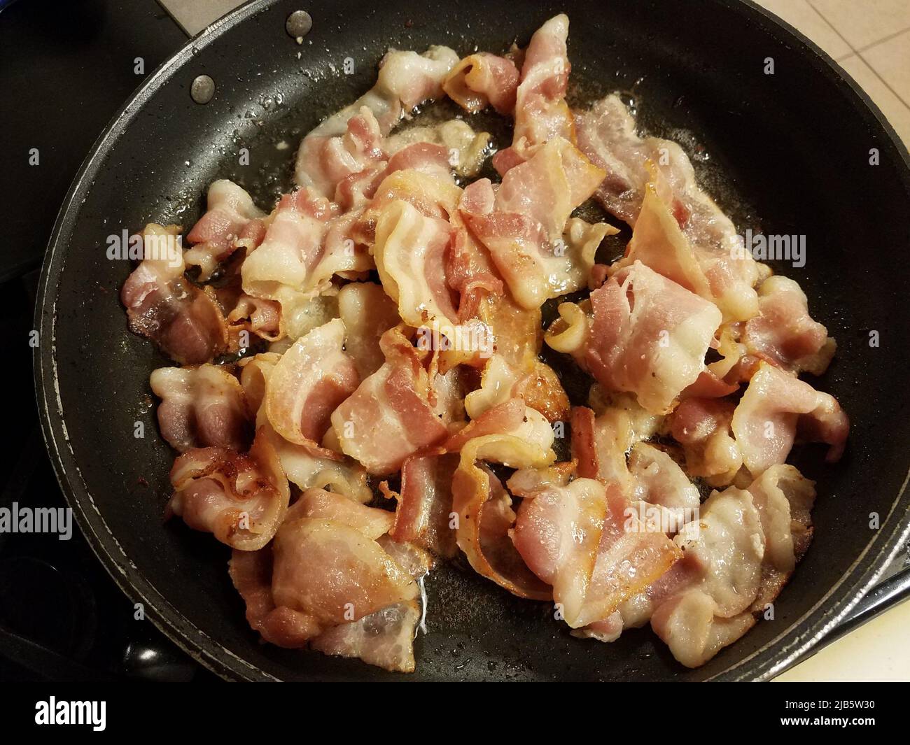 bacon strips cooking in frying pan or skillet Stock Photo Alamy