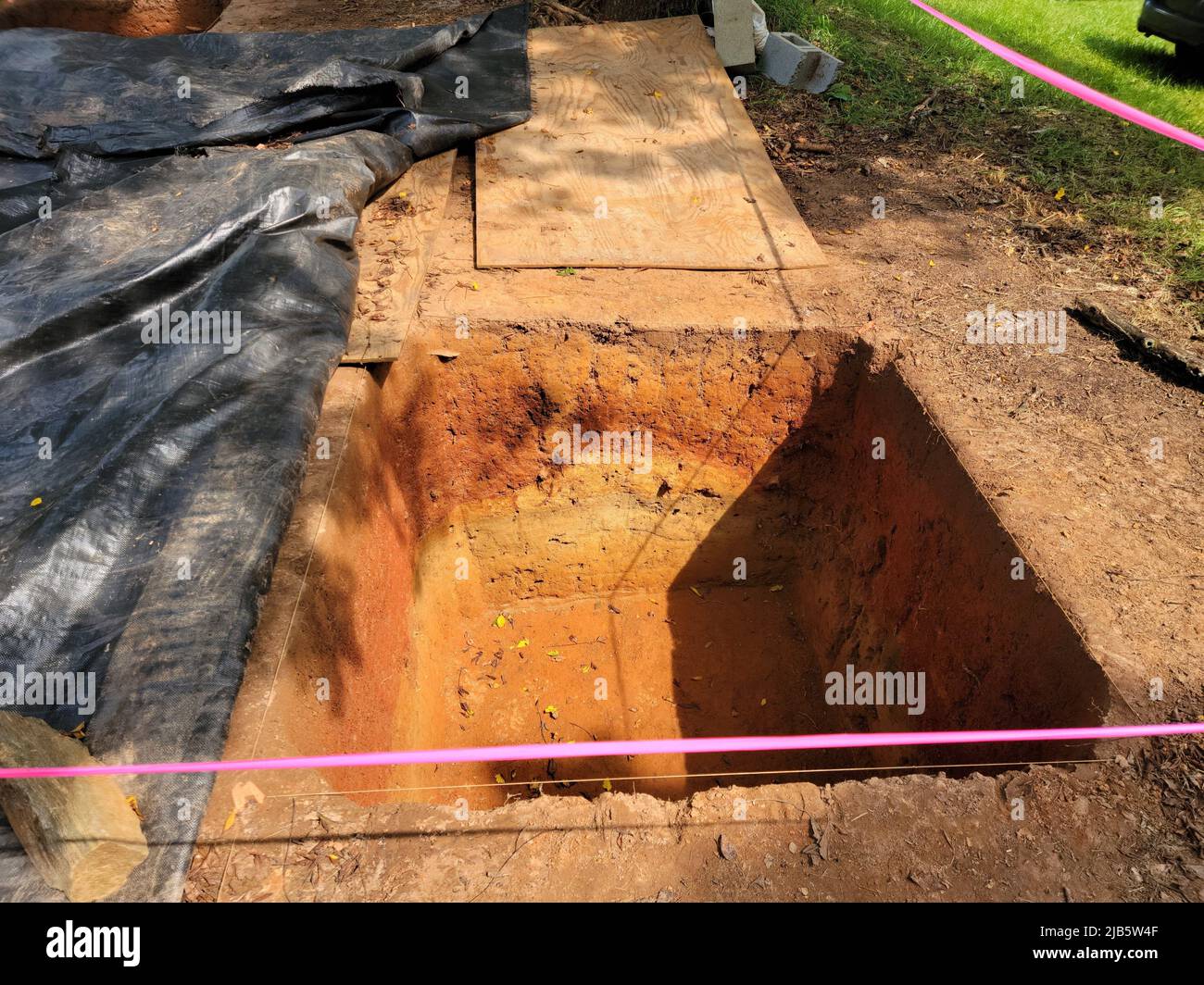 squae plot of dirt or hole in grass or lawn for archeology Stock Photo