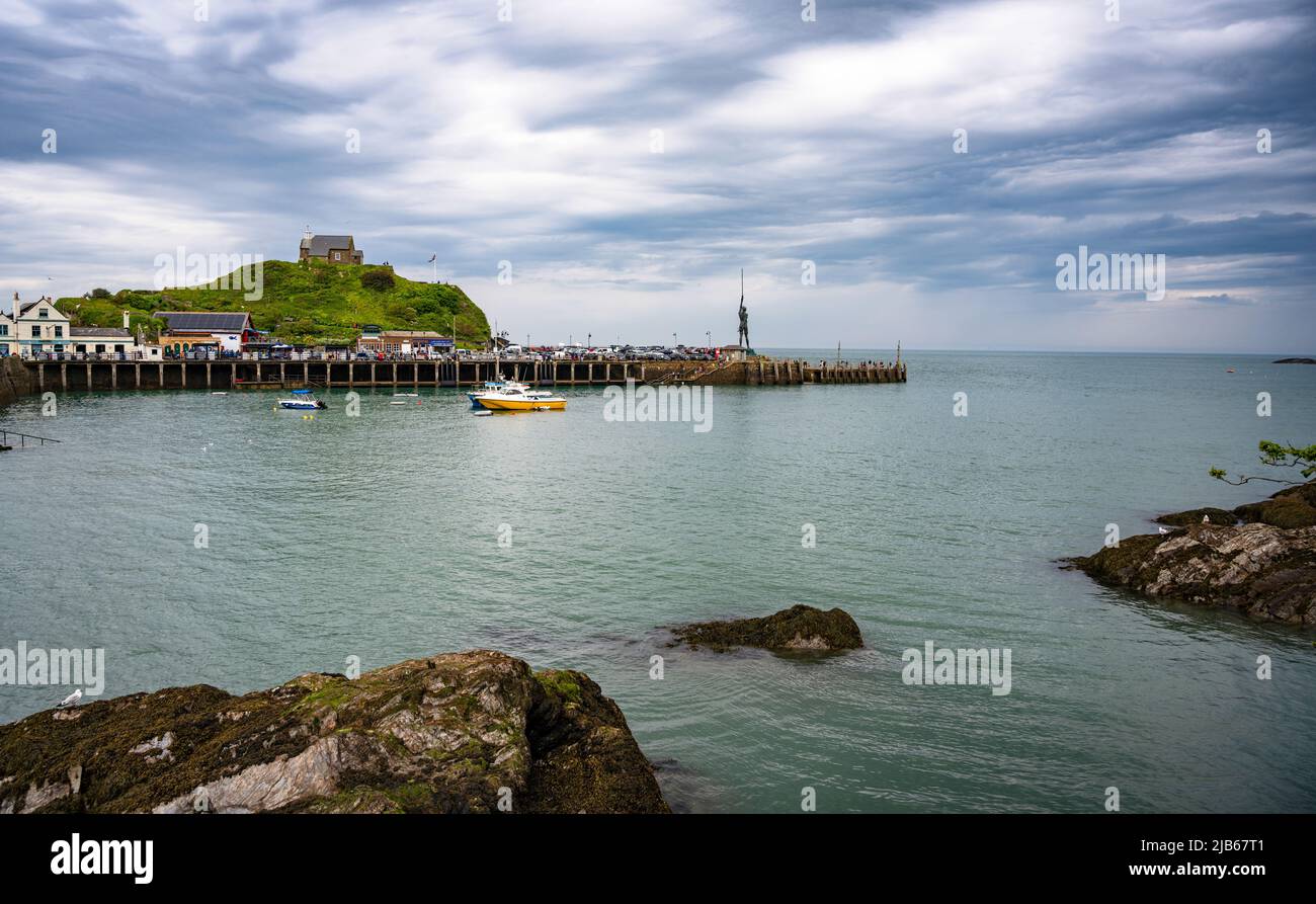 Harbour at the seaside resort of Ilfracombe, Devon, UK. St. Nicholas's Chapel on Lantern Hill and Damien Hirst's statue 'Verity' on the pier are seen. Stock Photo