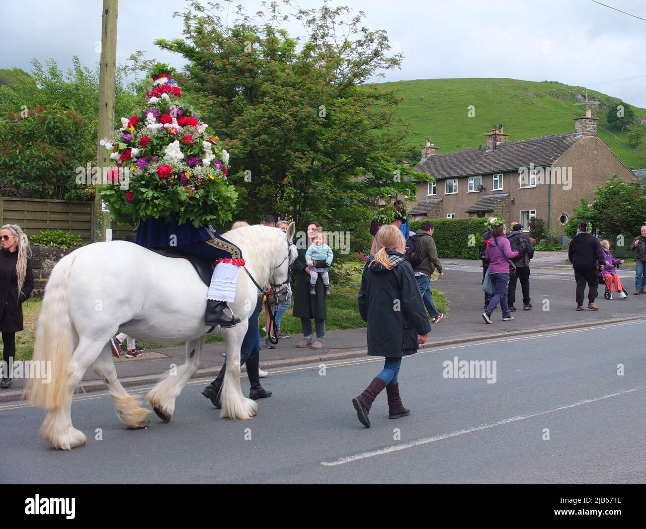 The Castleton Garland King wearing a hooped garland of flowers rides on horseback through village during the ancient Castleton Garland Ceremony 2022 Stock Photo