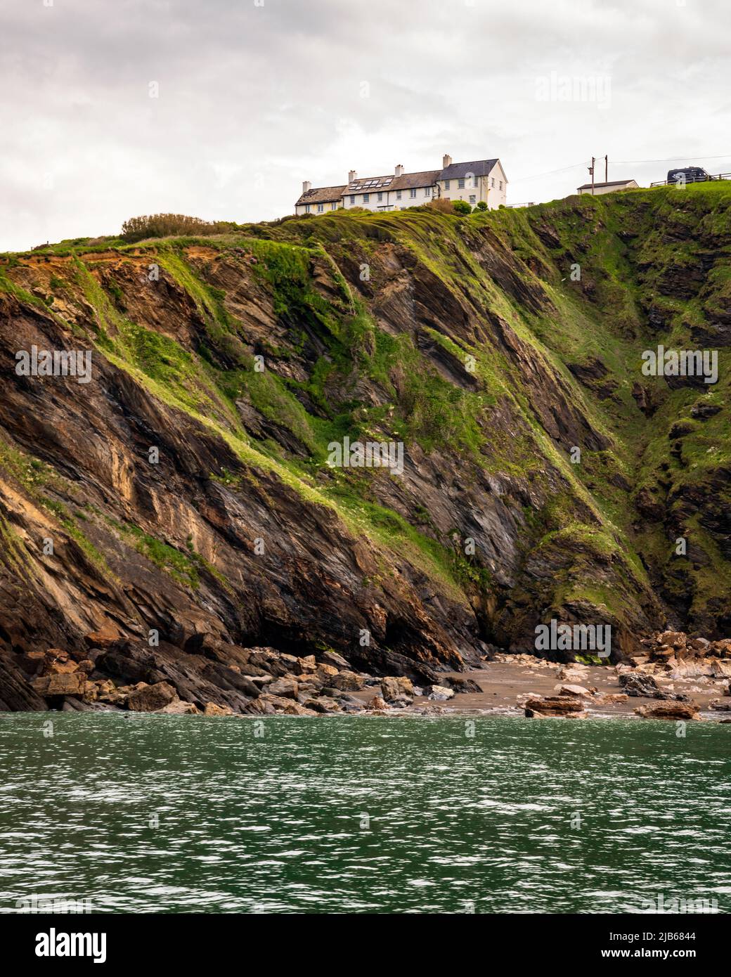 Former coast guard cottages above cliffs overlooking Hele Bay near Ilfracombe, Devon, UK. Stock Photo