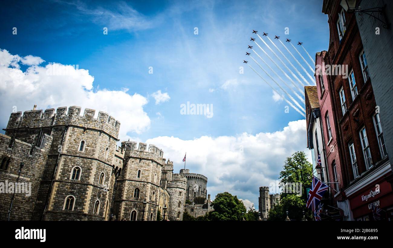 The RAF's iconic Red Arrows Display Team 'smoke on' fly past over Windsor Castle in celebration of The Queen's Platinum Jubilee 2022 Stock Photo