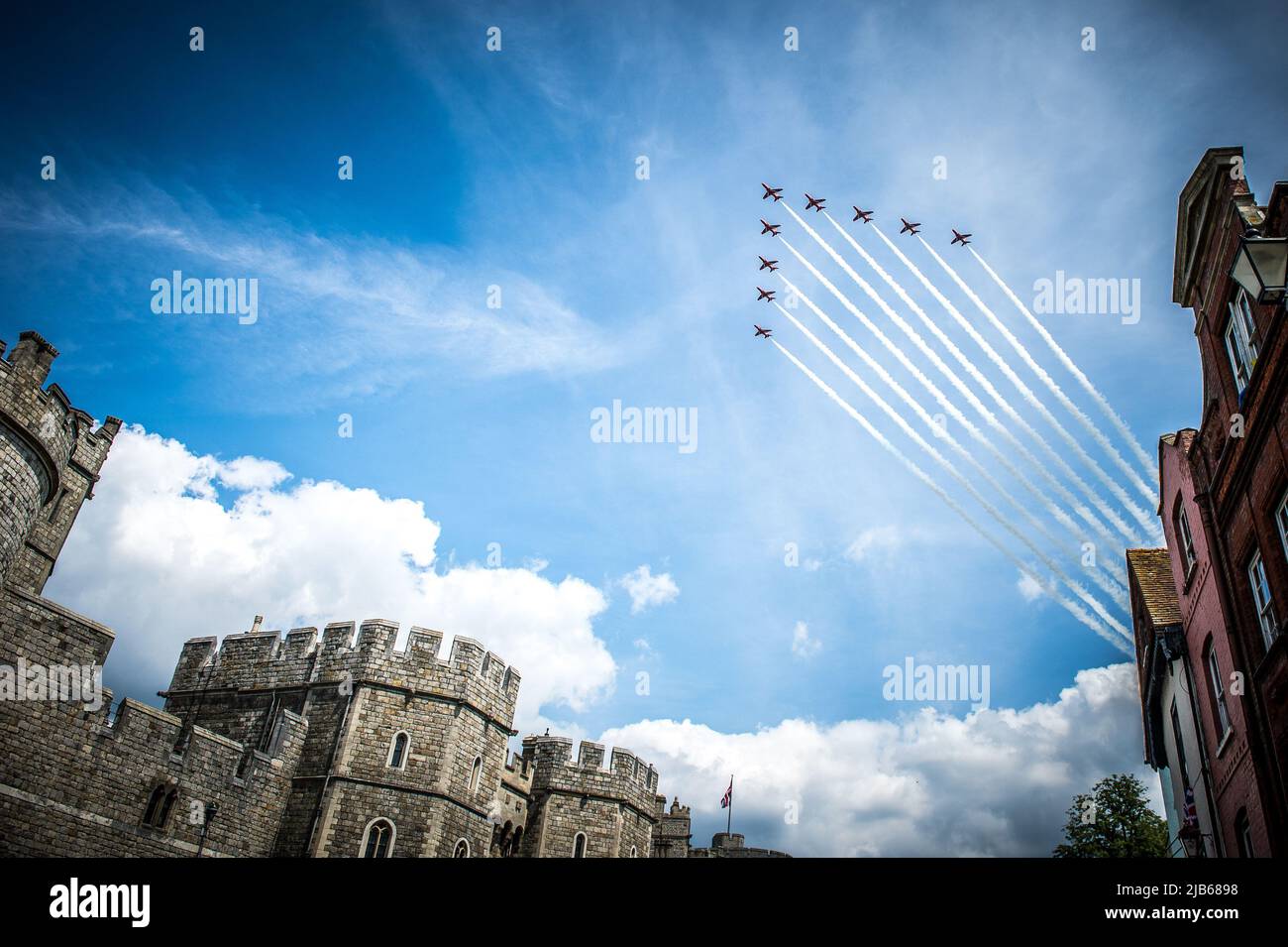 The RAF's iconic Red Arrows Display Team 'smoke on' fly past over Windsor Castle in celebration of The Queen's Platinum Jubilee 2022 Stock Photo