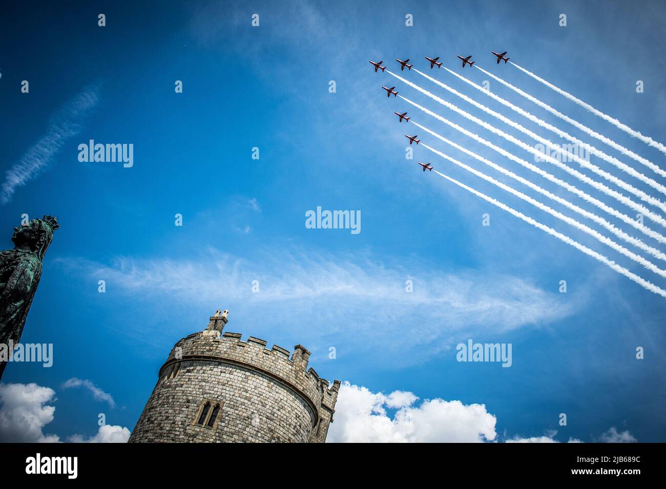 The RAF's iconic Red Arrows Display Team 'smoke on' fly past over Windsor Castle in celebration of The Queen's Platinum Jubilee 2022 Stock Photo