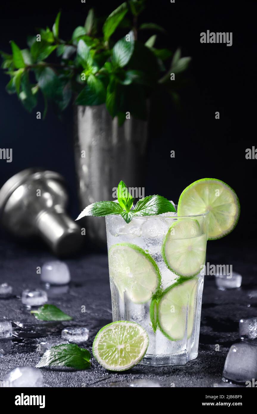 Cocktail Mojito or Lemonade with Lime, Mint and Ice on Dark Background. Concept Fresh Summer Drinks Stock Photo