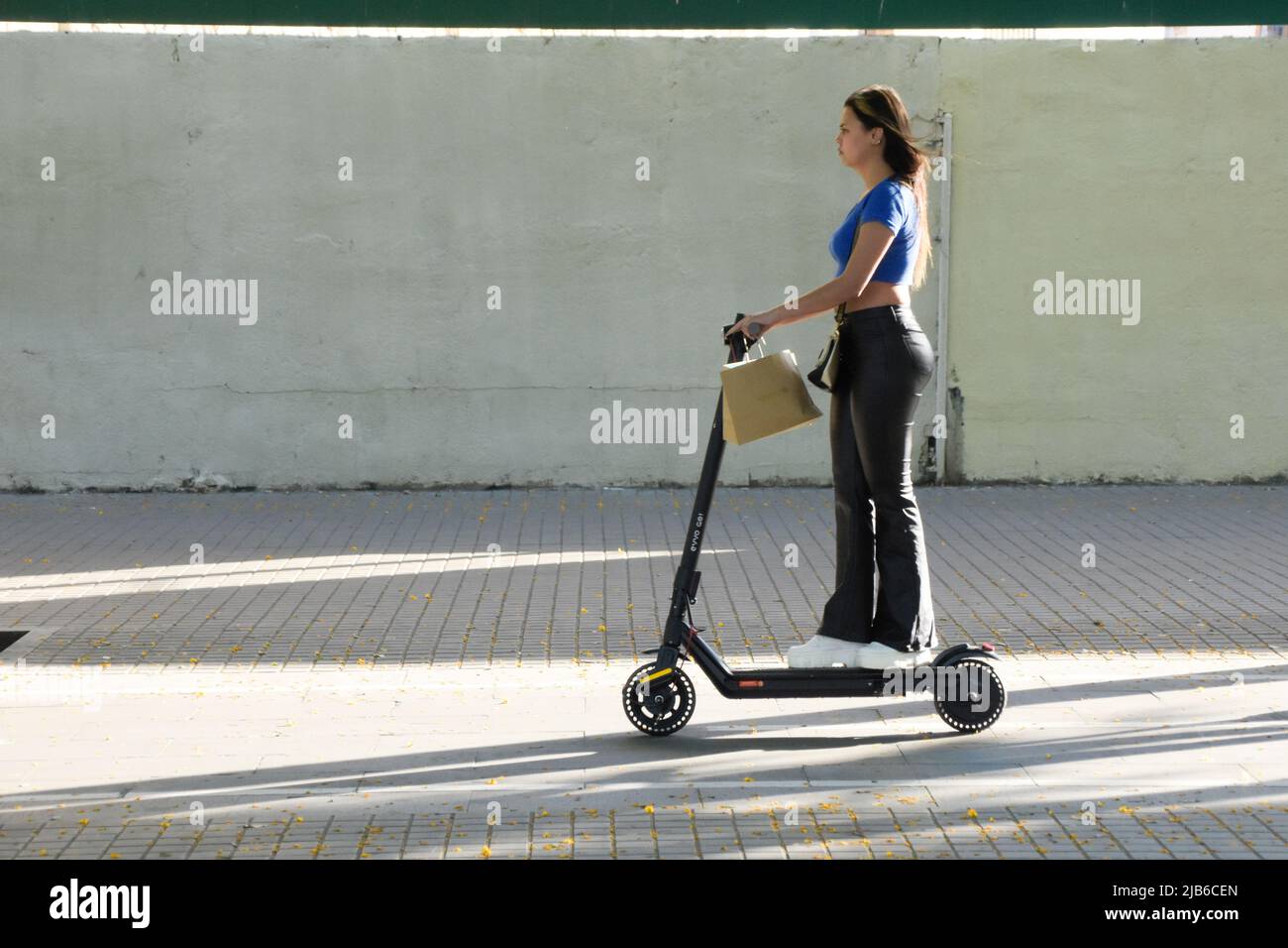 A young woman riding an electric scooter in a street Stock Photo Alamy