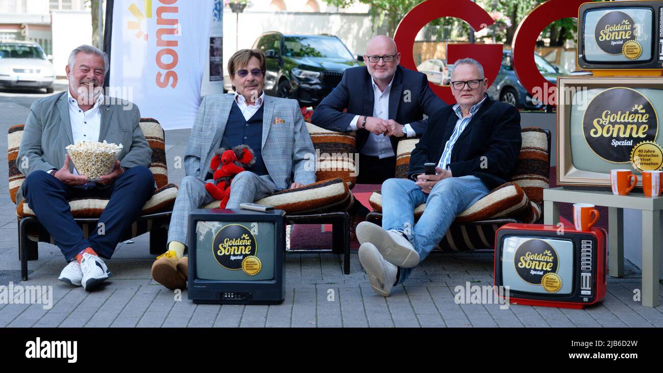 Essen, Germany. 03rd June, 2022. Presenters Harry Wijnvoord (l-r), Jörg Draeger and Ulli Potofski sit on armchairs during a photo session before a press conference for the 'Goldene Sonne Spezial' event, sonnenklar.TV's gala. Behind them kneels Andreas Lambeck, Managing Director of sonnenklar.TV. Credit: Henning Kaiser/dpa/Alamy Live News Stock Photo