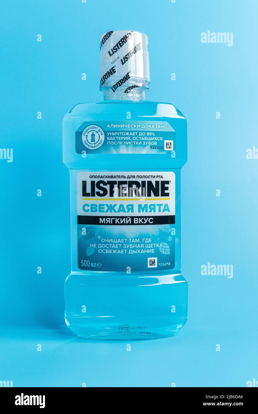 Tyumen, Russia-February 06, 2022: Listerine fresh mint is a brand of antiseptic mouthwash product, blue background. Vertical photo Stock Photo