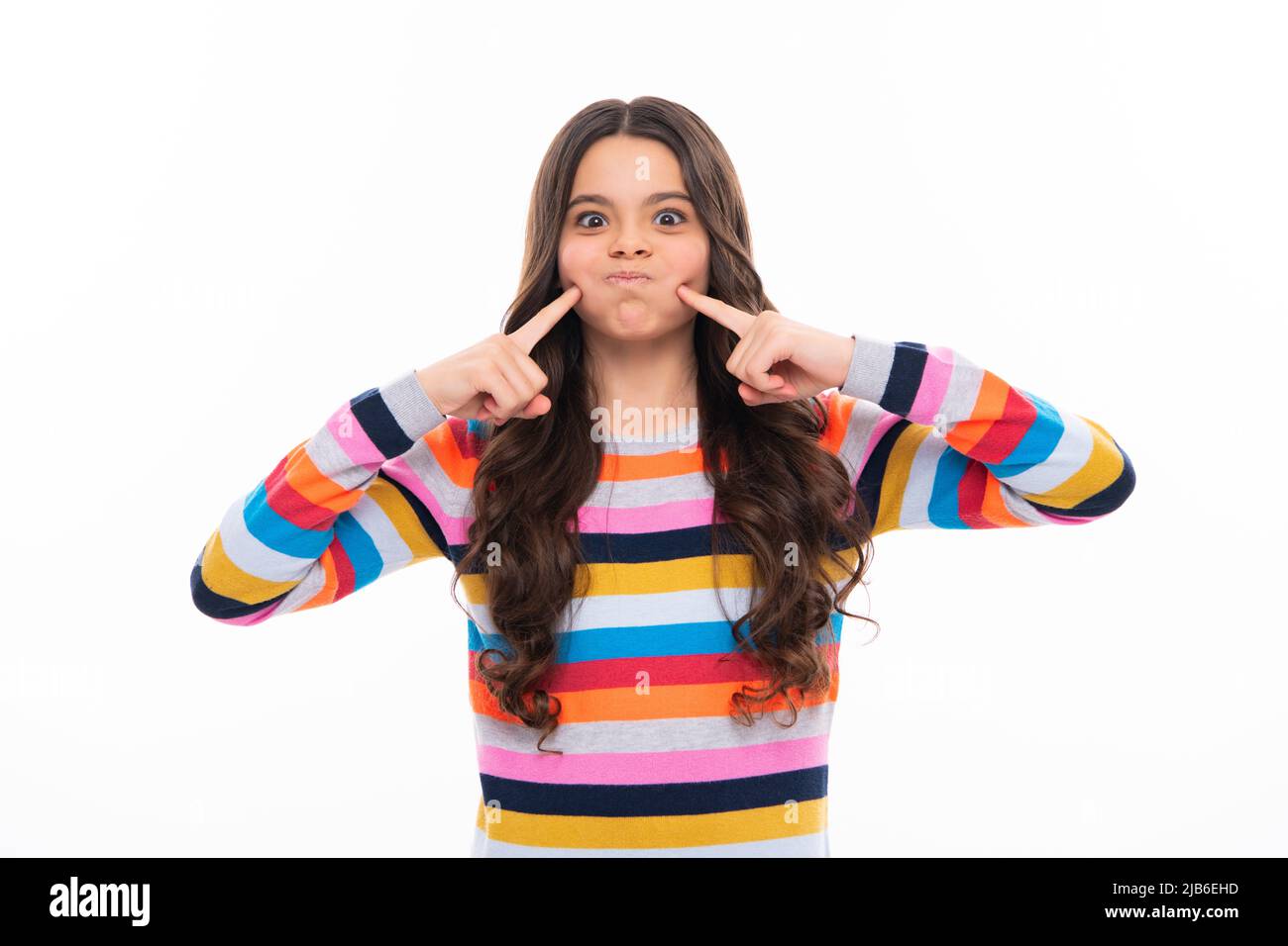 Funny face. Beautiful teen child pinching cheeks with index finger, showing cheek, funny photo, amusing, aesthetics concept, cheek. Stock Photo