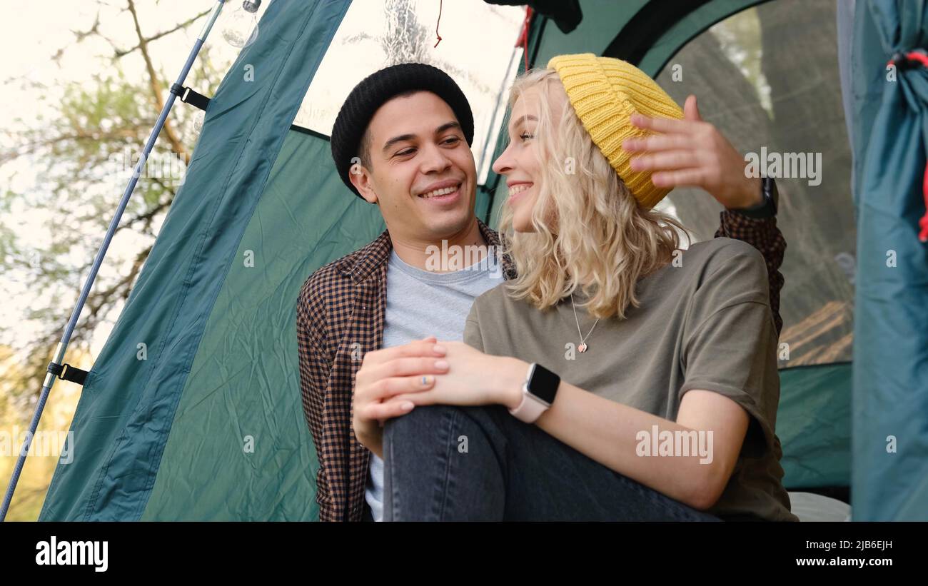 Romantic couple camping outdoors and sitting in a tent. Happy Man and ...