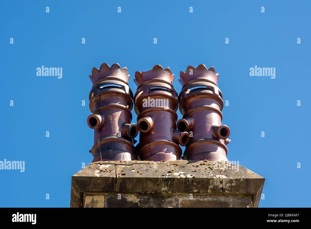 A trio of unique chimney pots against a blue sky Stock Photo