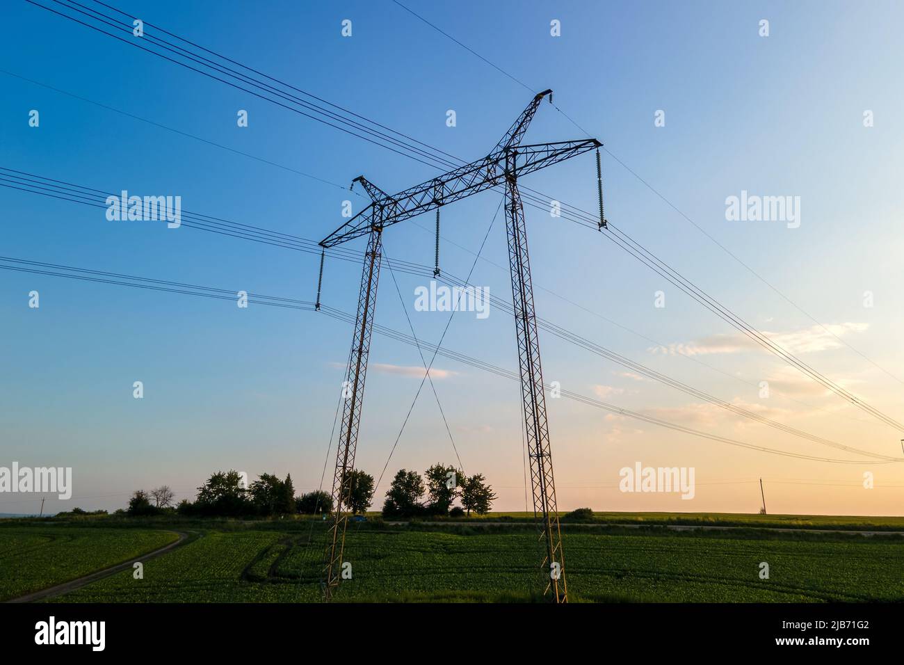 High voltage towers with electric power lines at sunset Stock Photo - Alamy