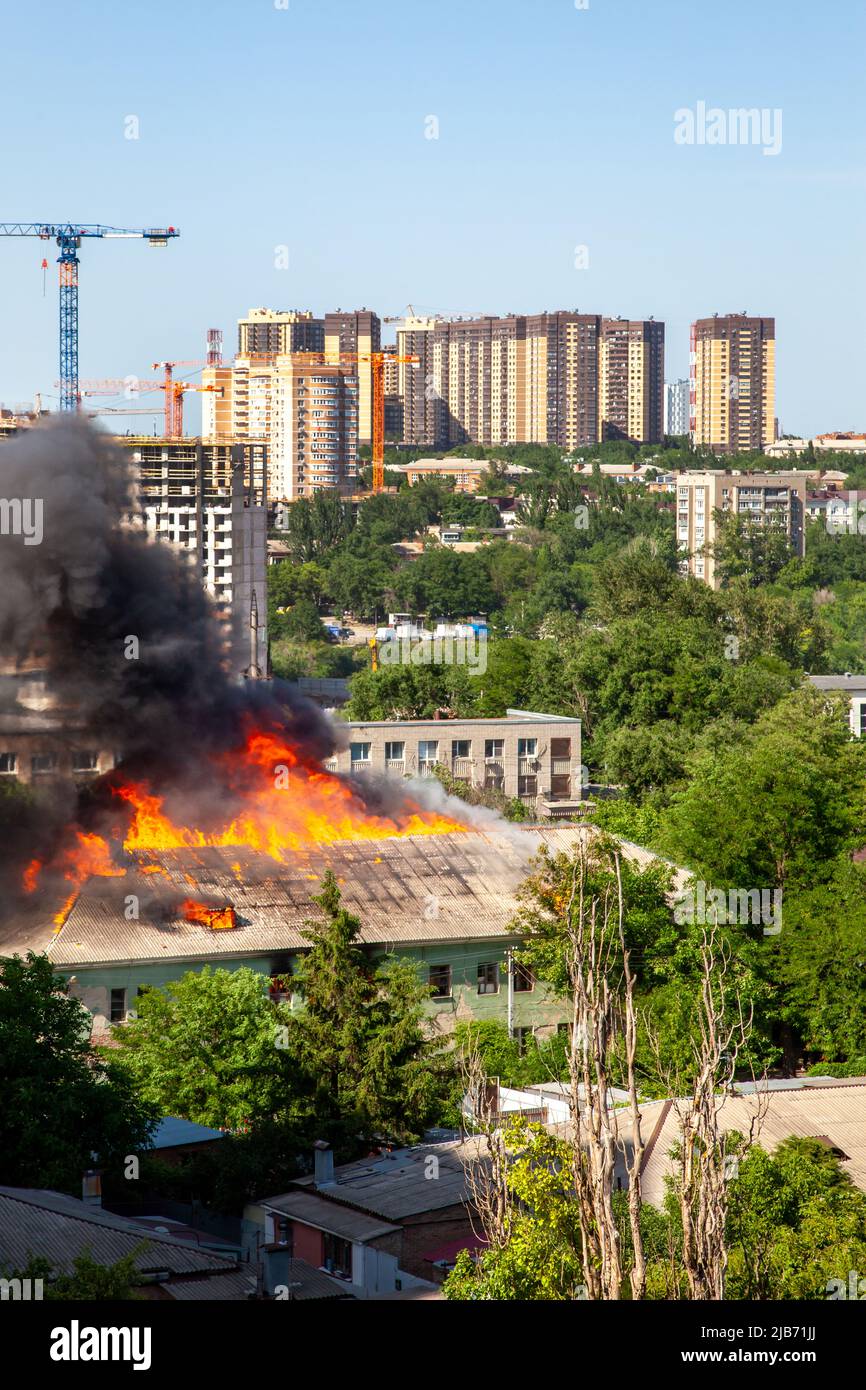 Old and new. An old abandoned building is burning against the ...