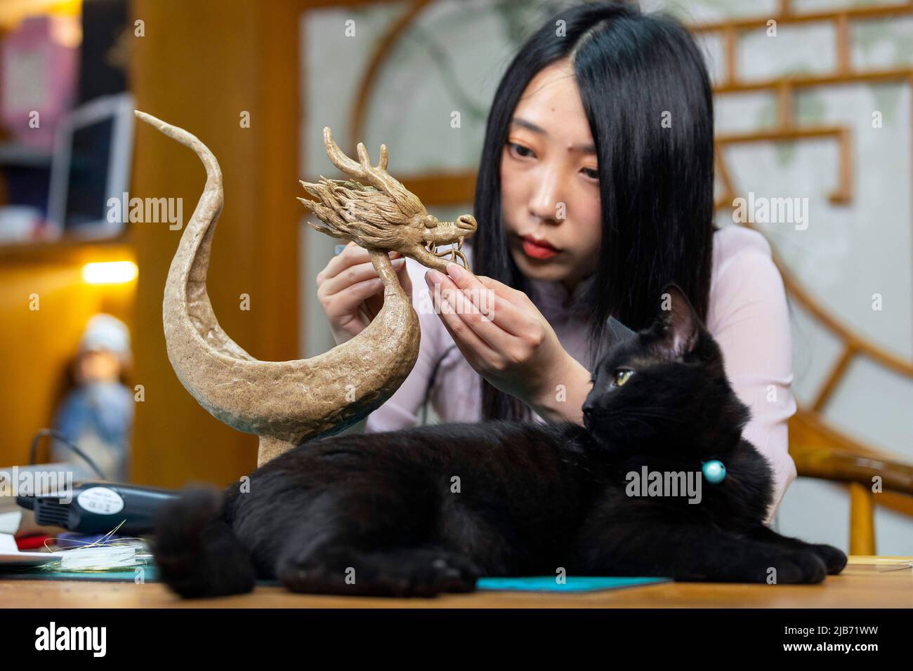 Chengdu, China's Sichuan Province. 28th May, 2022. Craftswoman Yan Hong makes a dragon boat at a workshop in Pidu District of Chengdu City, southwest China's Sichuan Province, May 28, 2022. Yan Hong, a craftswoman and a lover of traditional Chinese culture, made a dragon boat decoration with cans as the main material ahead of the Dragon Boat Festival. Yan has made more than 200 pieces of handicrafts in traditional Chinese style since 2018, some of which were made of material available in daily life such as cans and curtain gauze. Credit: Shen Bohan/Xinhua/Alamy Live News Stock Photo