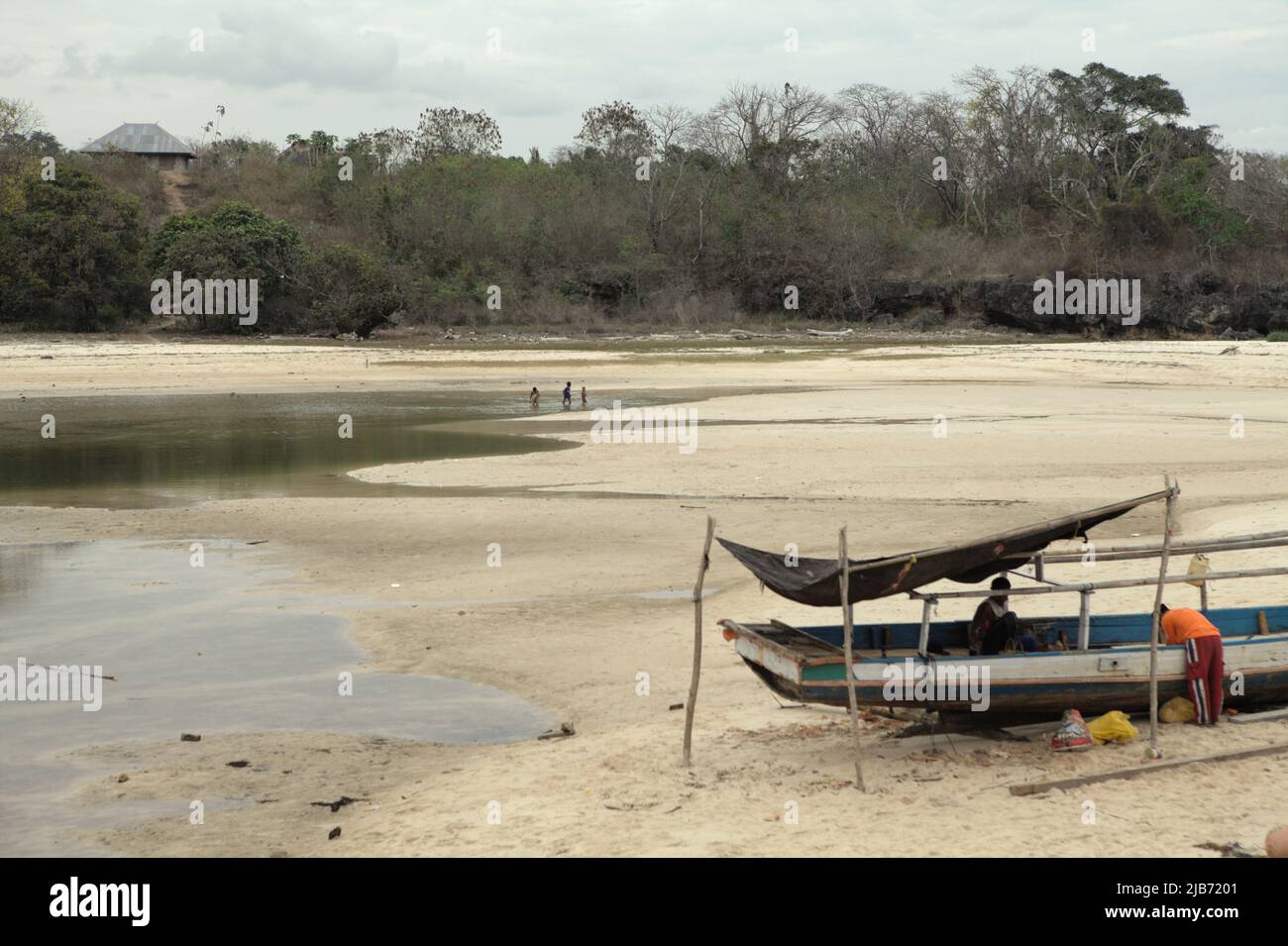 A fishing boat on intertidal beach during low tide on a cloudy day in Waikelo, Tambolaka, Southwest Sumba, East Nusa Tenggara, Indonesia. Stock Photo