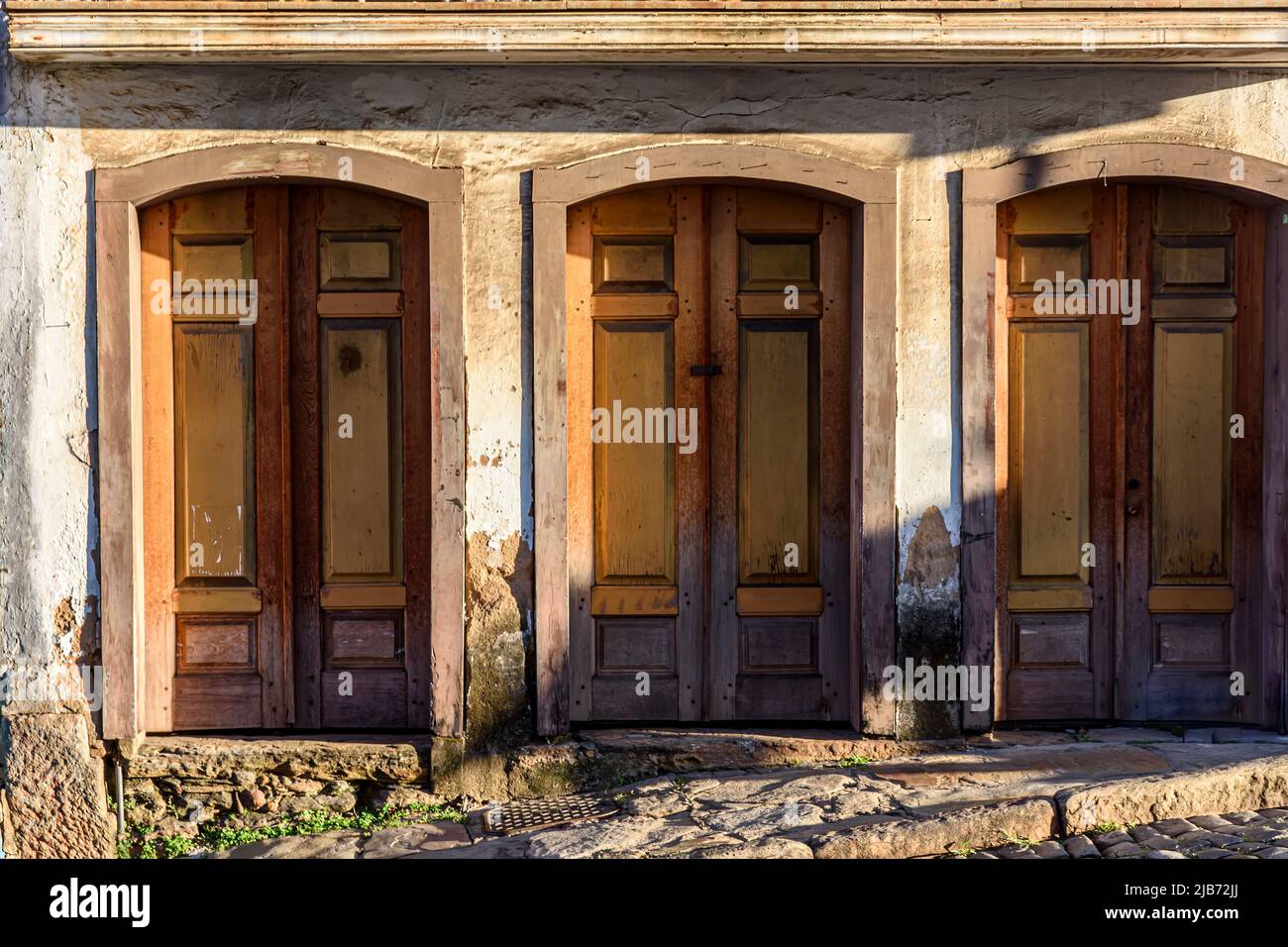 Old wooden doors spoiled by time on the facade of a colonial style house in the city of Ouro Preto, Minas Gerais Stock Photo