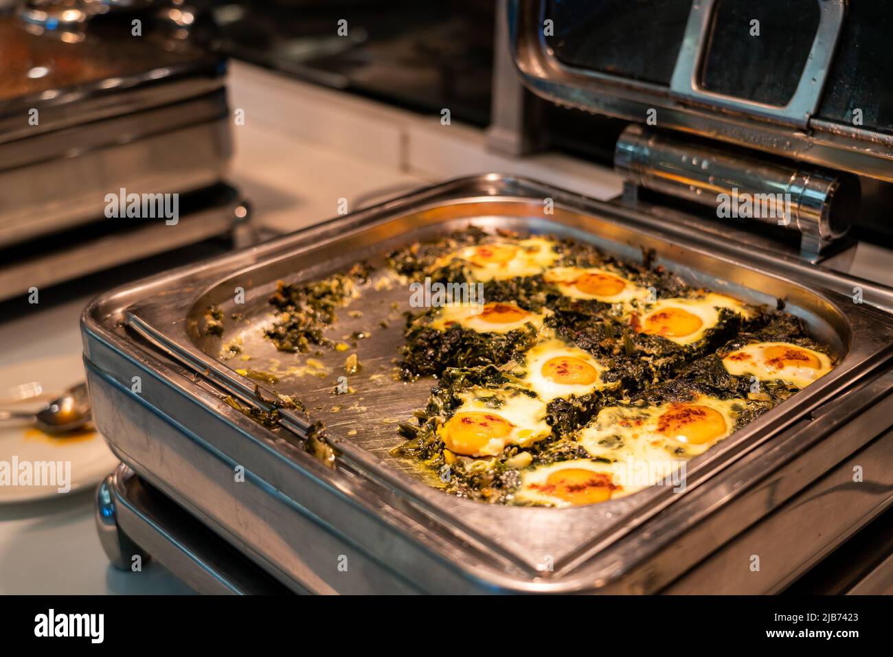 Breakfast buffet food in heating trays in hotel restaurant with eggs