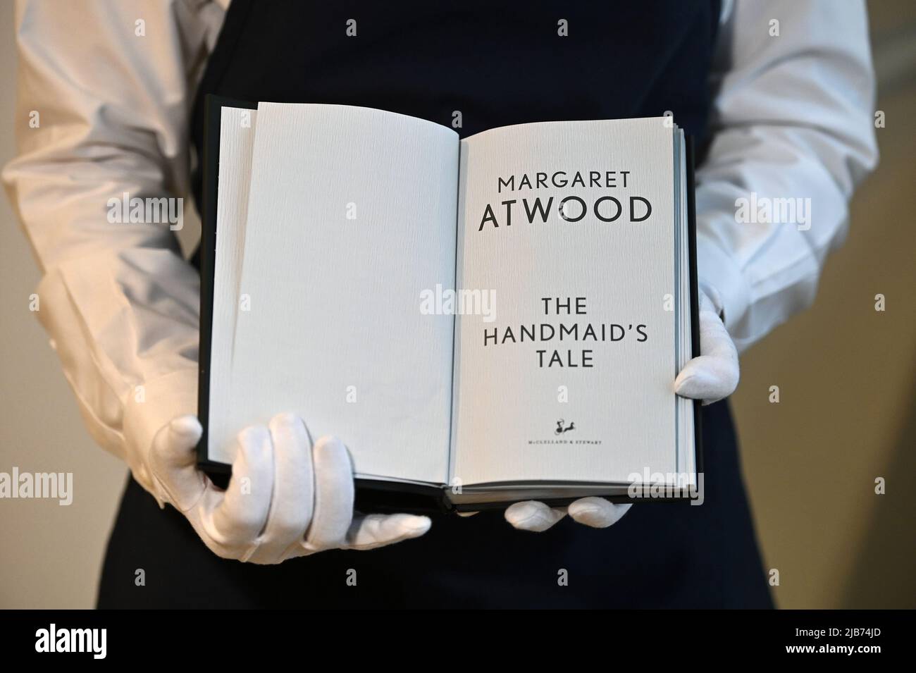 New York, USA. 03rd June, 2022. An “Unburnable” edition of author Margaret Atwood's “The Handmaid's Tale” is held by art handler Marika Yoshino at Sotheby's, New York, NY, June 3, 2022. The one-of-a-kind edition printed using fireproof materials is to be auctioned off for PEN America. (Photo by Anthony Behar/Sipa USA) Credit: Sipa USA/Alamy Live News Stock Photo