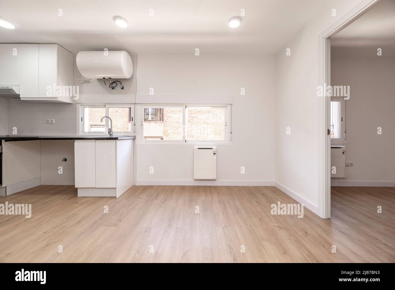Open plan kitchen with white and a glossy black countertop