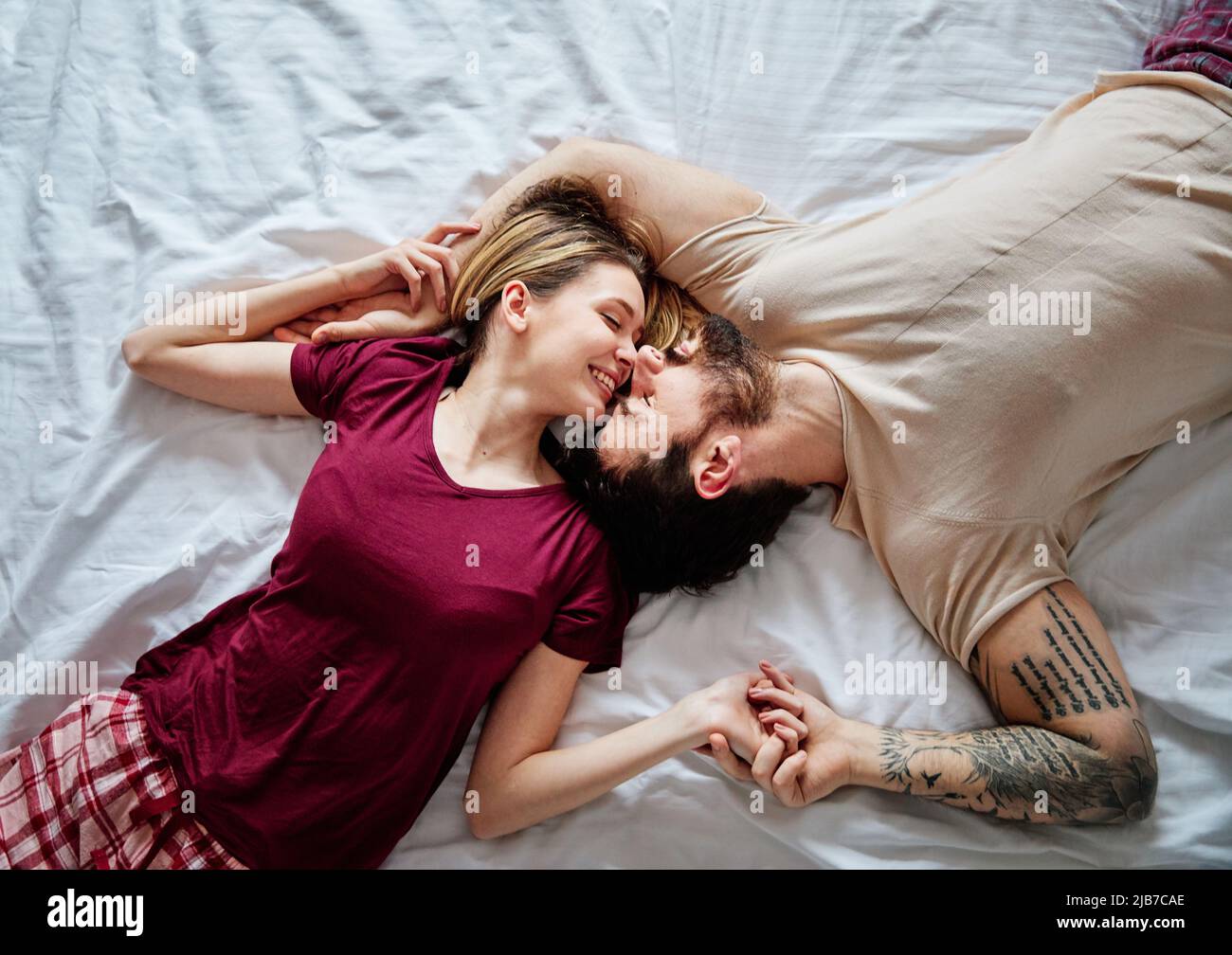 couple love bedroom bed lying romance happy relationship valentine day together man woman Stock Photo