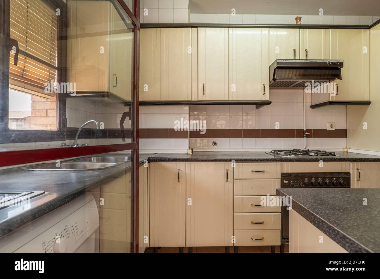 Apartment kitchen with beige with drawers and doors, black