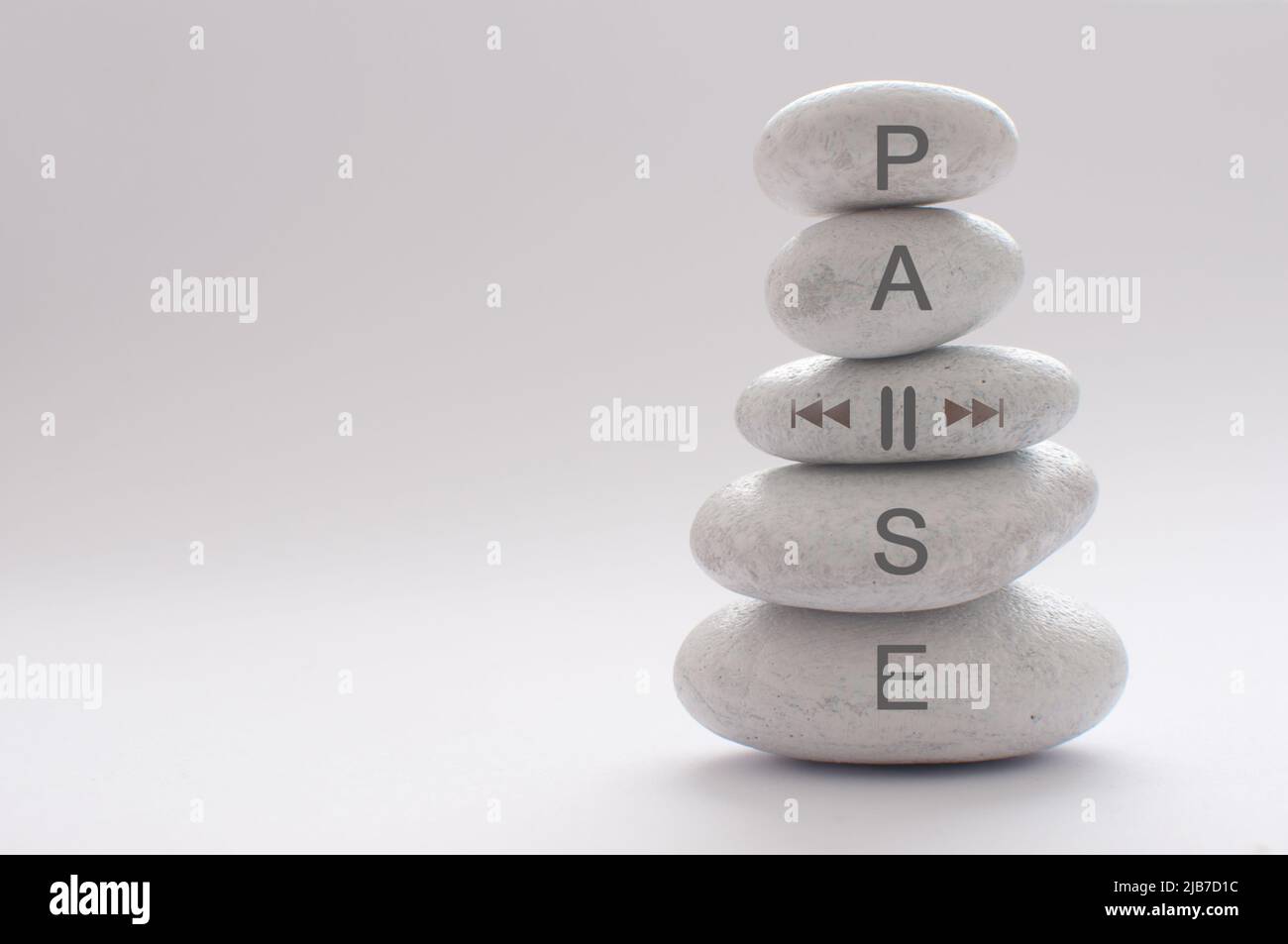 Yoga zen stones balancing on top of each other with pause symbol Stock Photo