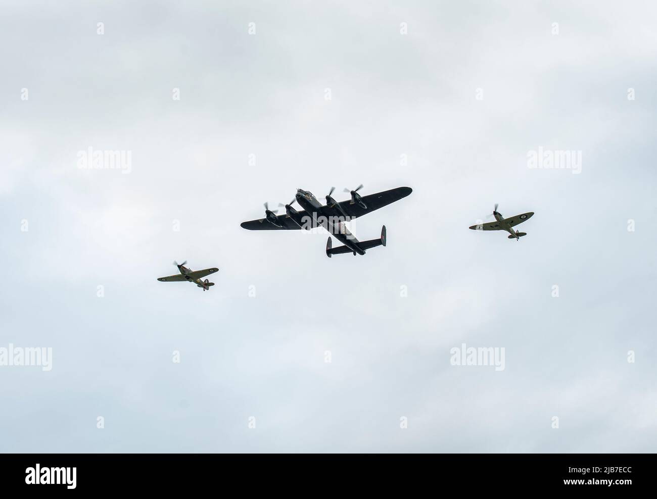 A Lancaster, Hurricane and a Spitfire bomber planes fly over Warmley, Bristol as part of the Queens Jubilee Flypast ay 2.30pm on 3rd June 2022 Stock Photo