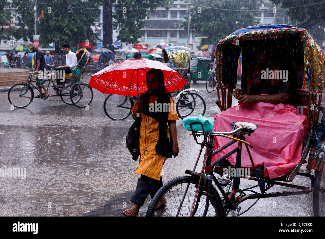 A woman walks on the road during rain in Dhaka, Bangladesh, June 03, 2022. REUTERS/Mohammad Ponir Hossain Stock Photo