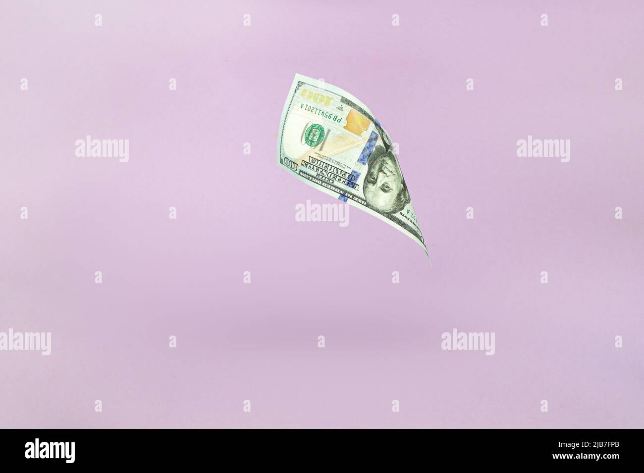 One hundred American dollars. 100. Flying of US dollar banknote on pink pastel background. Investment and saving concept Stock Photo