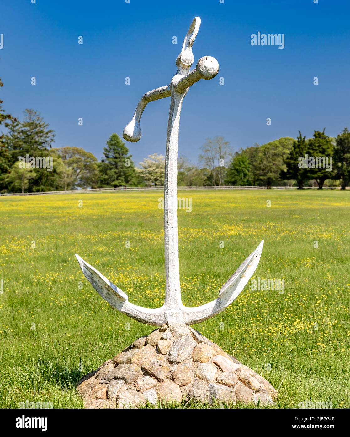 Old anchor mounted on a pile of rocks Stock Photo