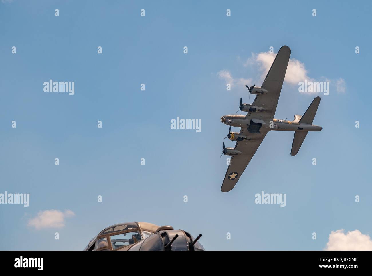 East Kirkby, Lincolnshire, UK – June 02 2022. A military Boeing B17 bomber flying over the cockpit of an Avro Lancaster bomber during a fly past at th Stock Photo