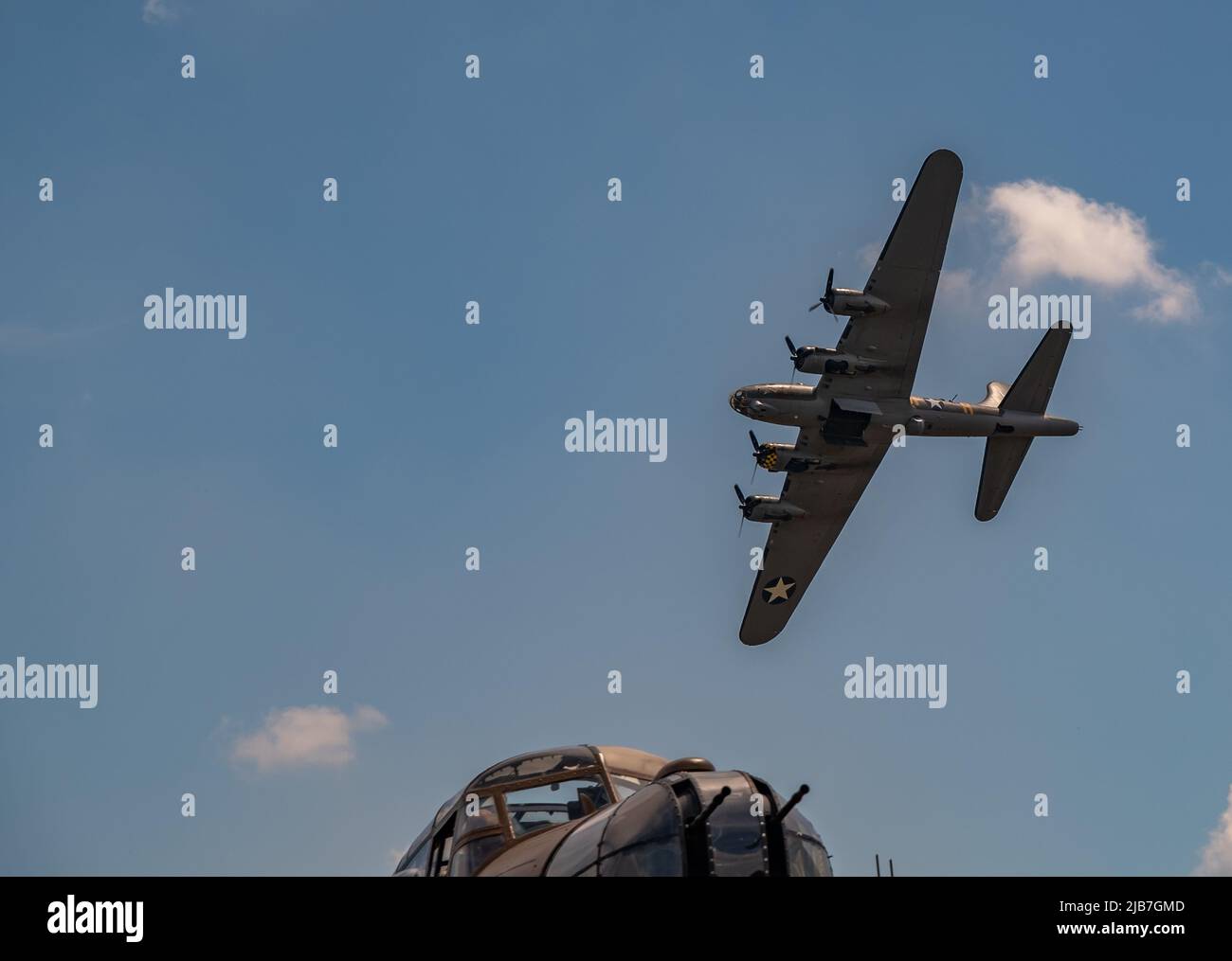 East Kirkby, Lincolnshire, UK – June 02 2022. A military Boeing B17 bomber flying over the cockpit of an Avro Lancaster bomber during a fly past at th Stock Photo