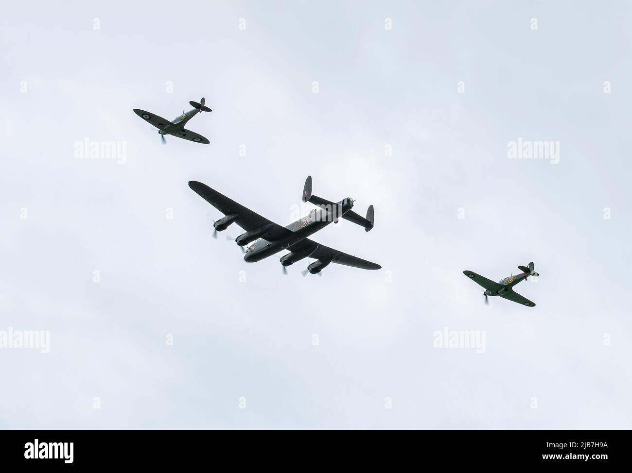 A Lancaster, Hurricane and a Spitfire bomber planes fly over Warmley, Bristol as part of the Queens Jubilee Flypast ay 2.30pm on 3rd June 2022 Stock Photo