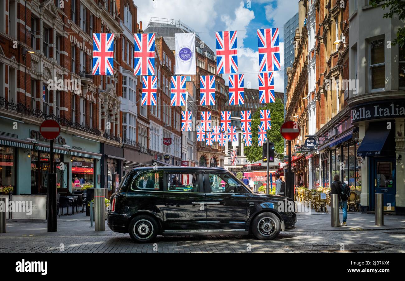 A TX City electric black cab waits for passengers under Jubilee bunting in central London Stock Photo