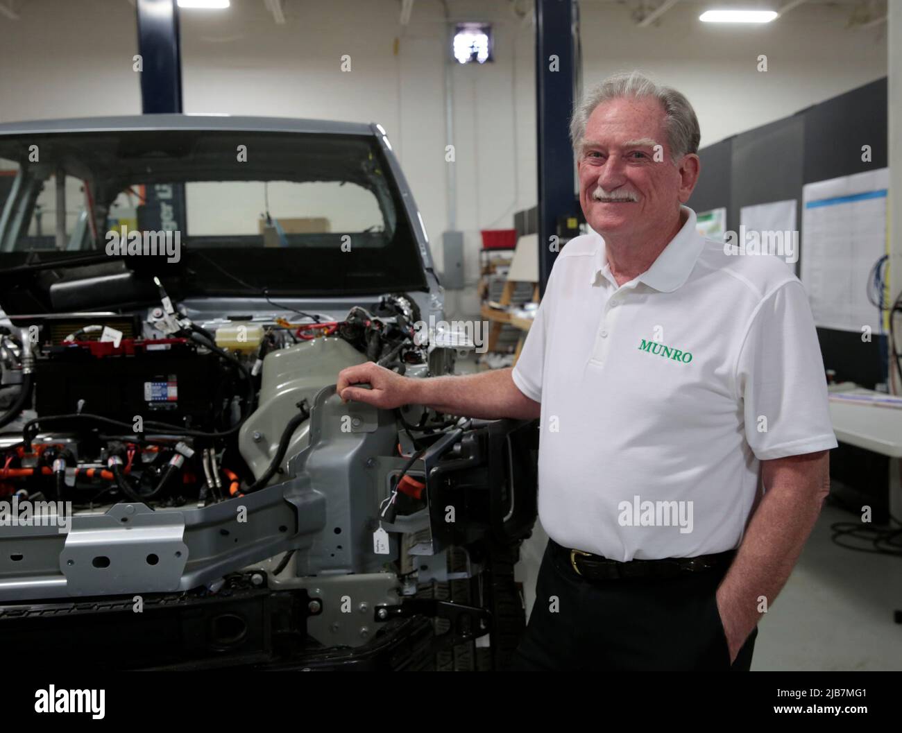 Manufacturing expert Sandy Munro poses next to a partially dismantled Rivian R1T electric truck during its teardown at the Munro & Associates headquarters in Auburn Hills, Michigan, U.S., June 3, 2022.  REUTERS/Rebecca Cook Stock Photo
