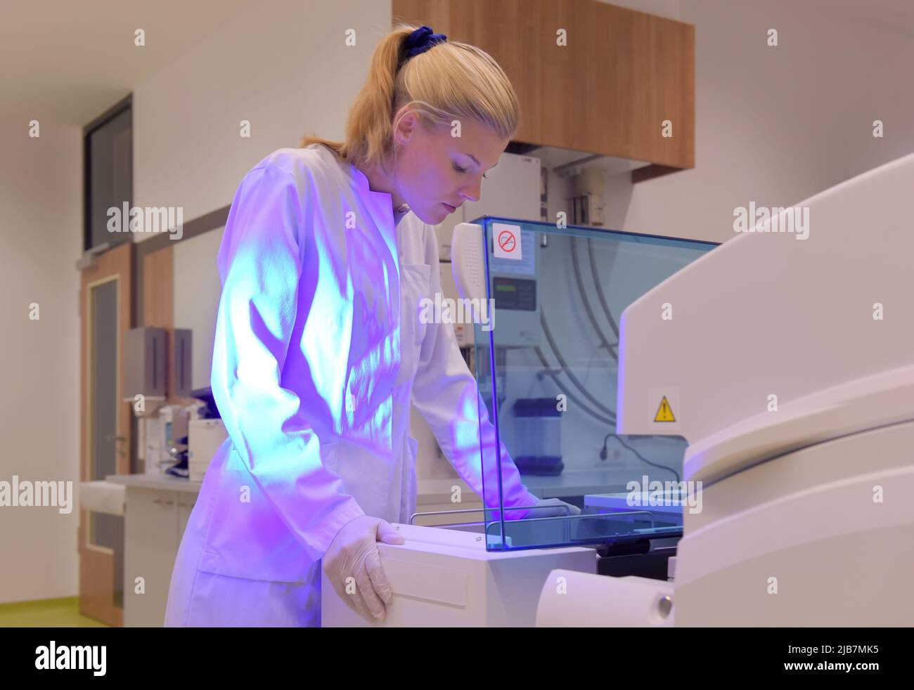 A young student takes up her duties as lab assistant. She wears a white