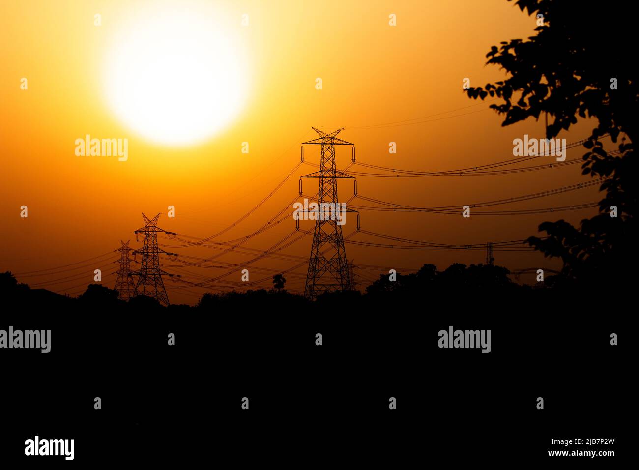 An electricity transmission pylon silhouetted Stock Photo