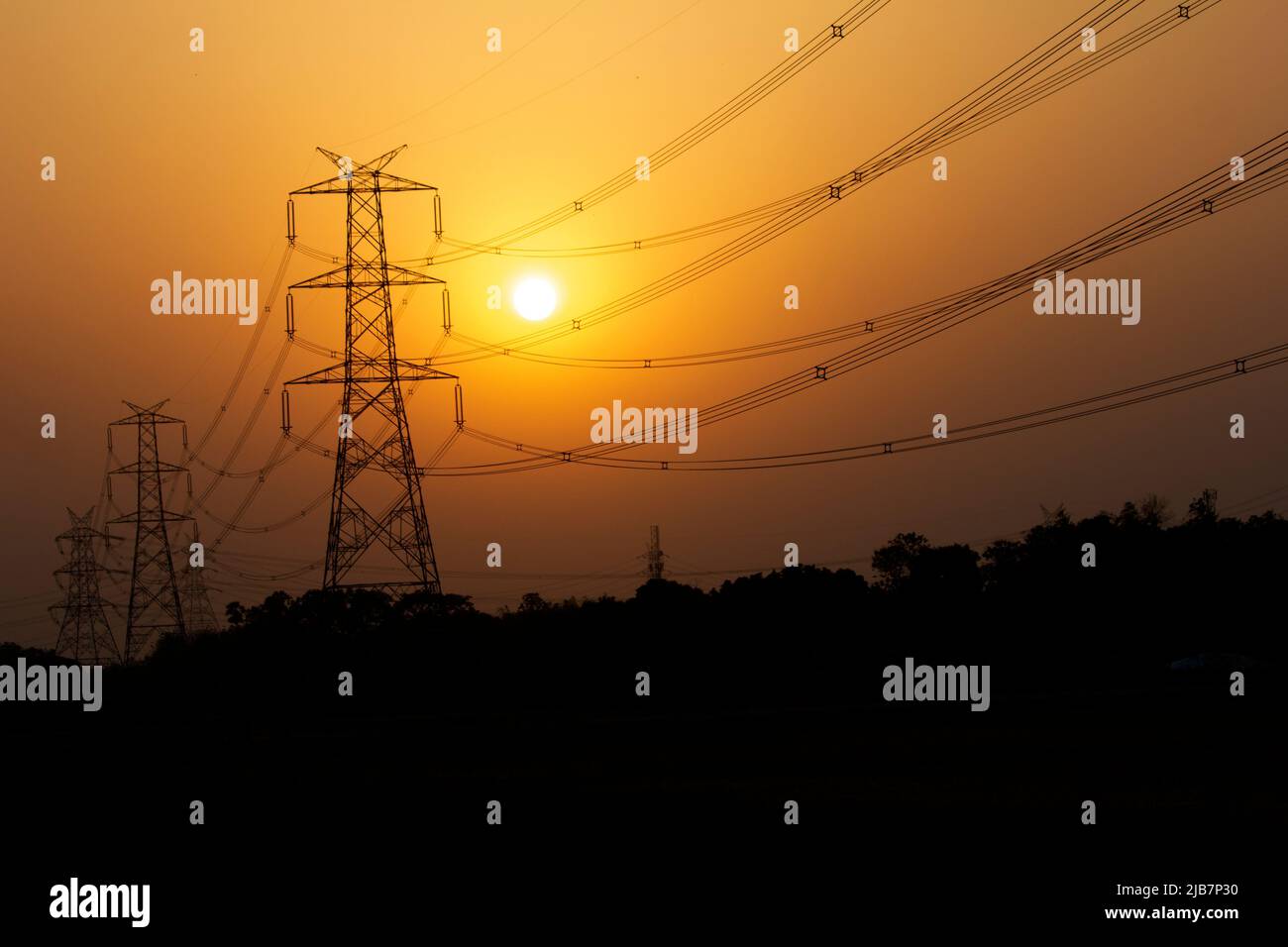 An electricity transmission pylon silhouetted Stock Photo