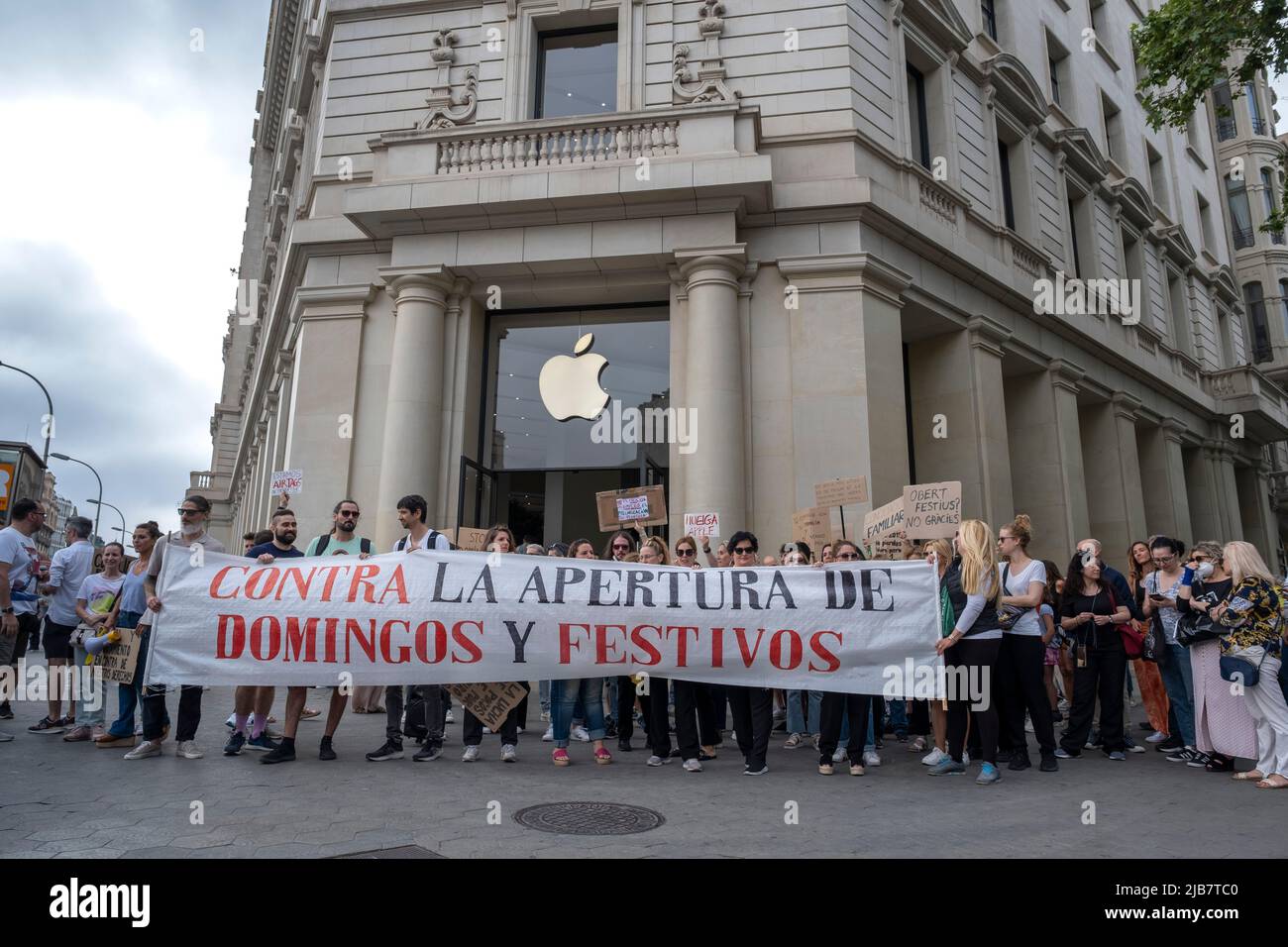Trade unionists and workers are seen holding the unitary banner against commercial opening on Sundays and public holidays in front of the door of the Apple store in Plaza de Catalunya. Shouting 'we want to reconcile work and family', trade unionists and workers in the retail sector have demonstrated in front of the emblematic shops on Passeig de Gràcia to protest the extension of working hours to Sundays approved by the Government of the Generalitat of Catalonia and ratified by the Barcelona City Council in order to define a new tourist area for commercial opening. Stock Photo