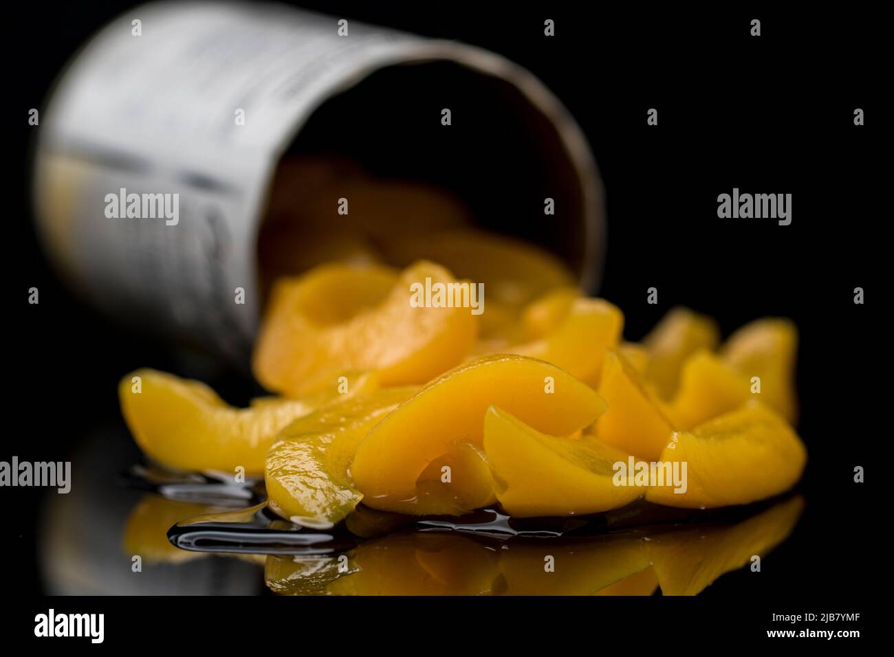 Food close up peach slices in a can. Packaged food in tin can. Stock Photo