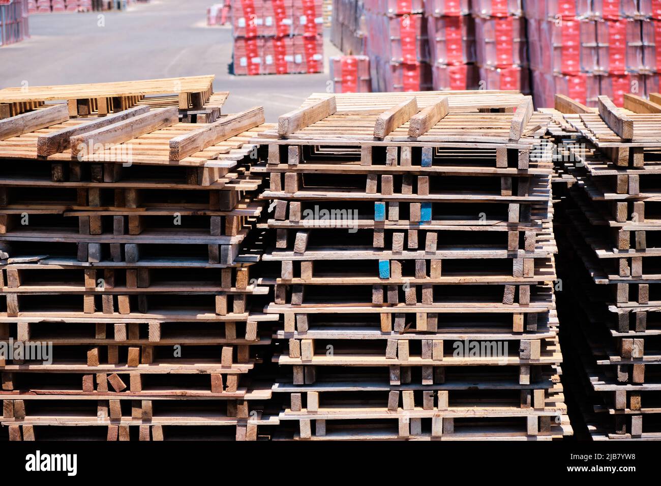 Wooden pallets stacked on a forecourt outside a factory. Stock Photo
