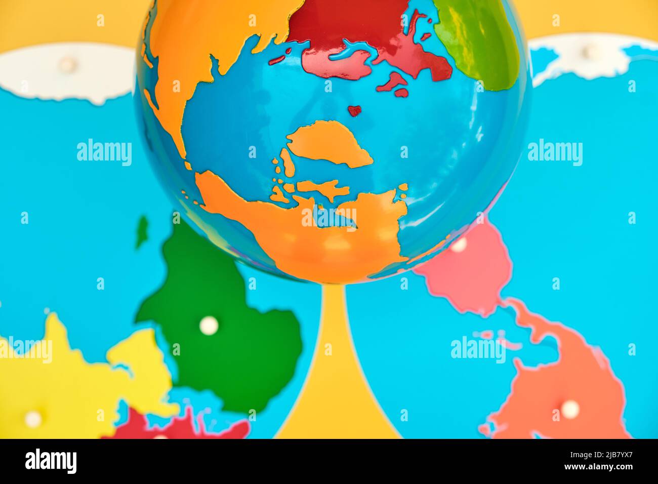 A brightly colored wooden map and globe used in a montessori school for education. Stock Photo