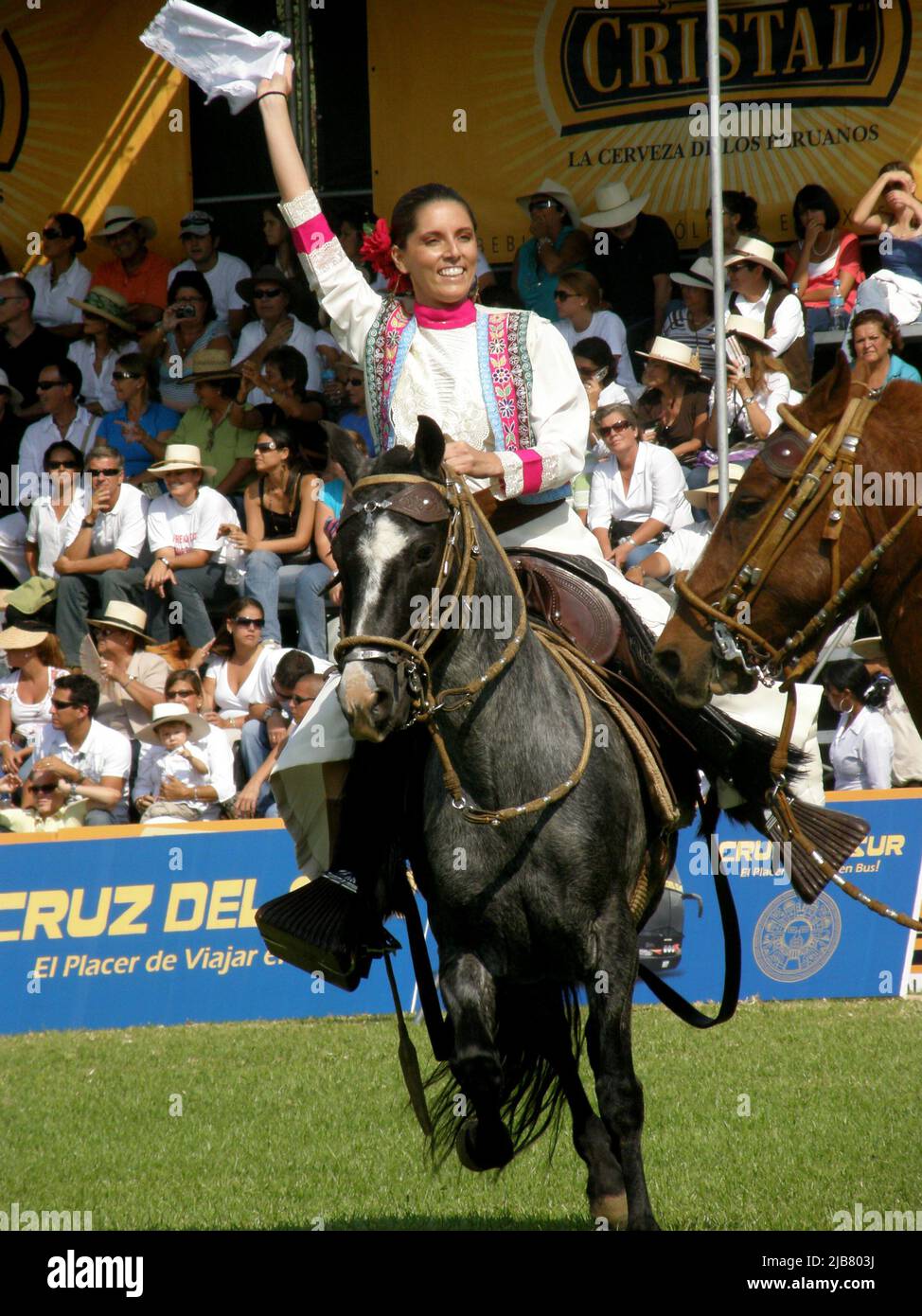 A girl dancing marinera, a Peruvian creole typical dance, on horseback during the championship
