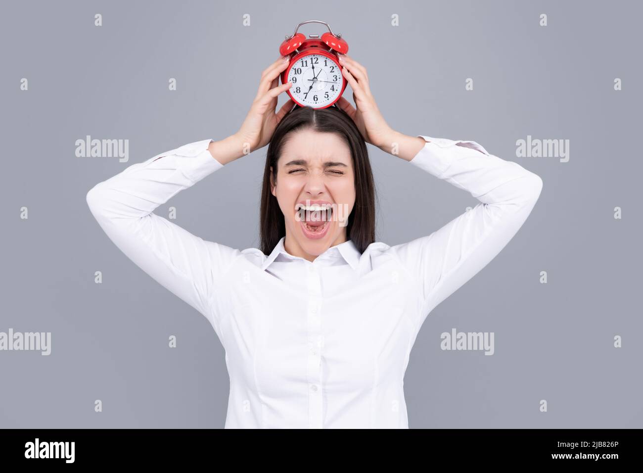 Funny excited woman at morning time holding alarm clock. Stock Photo