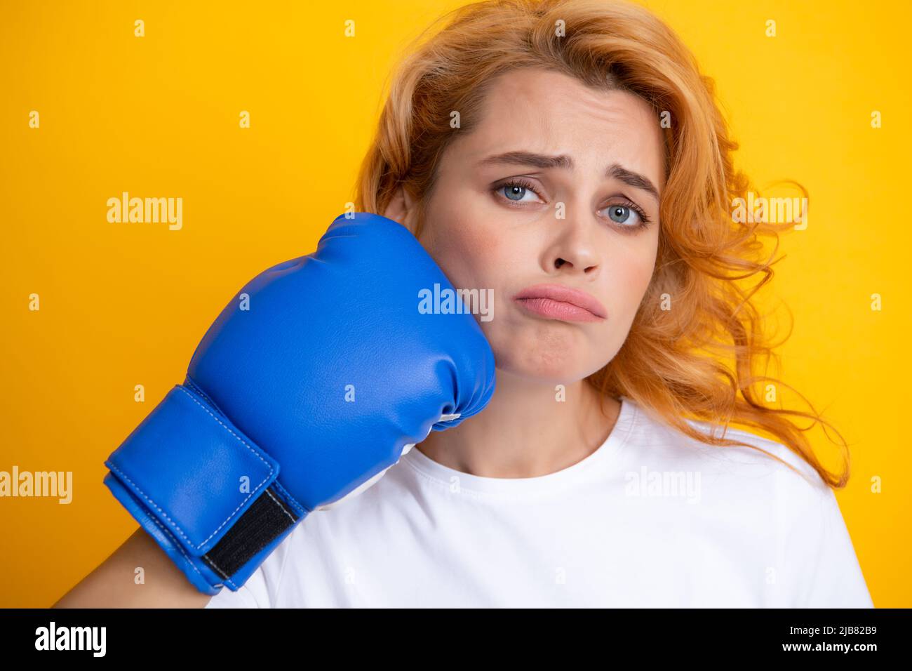 Funny woman with boxing gloves with punching face isolated on yellow background Woman in boxing gloves. Stock Photo