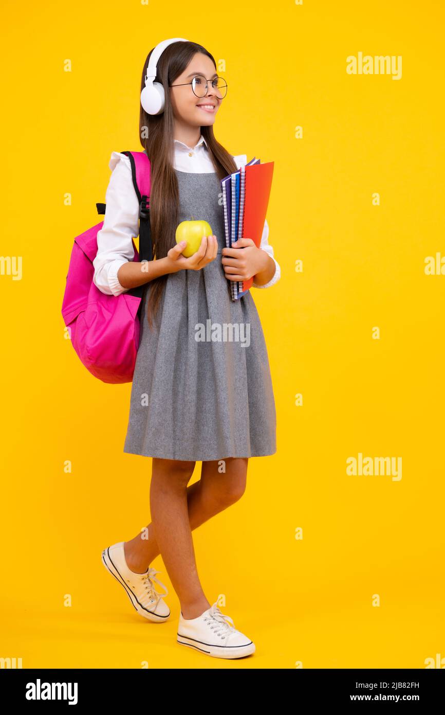 Back to school. Teenage school girl with bag hold apple and book, ready