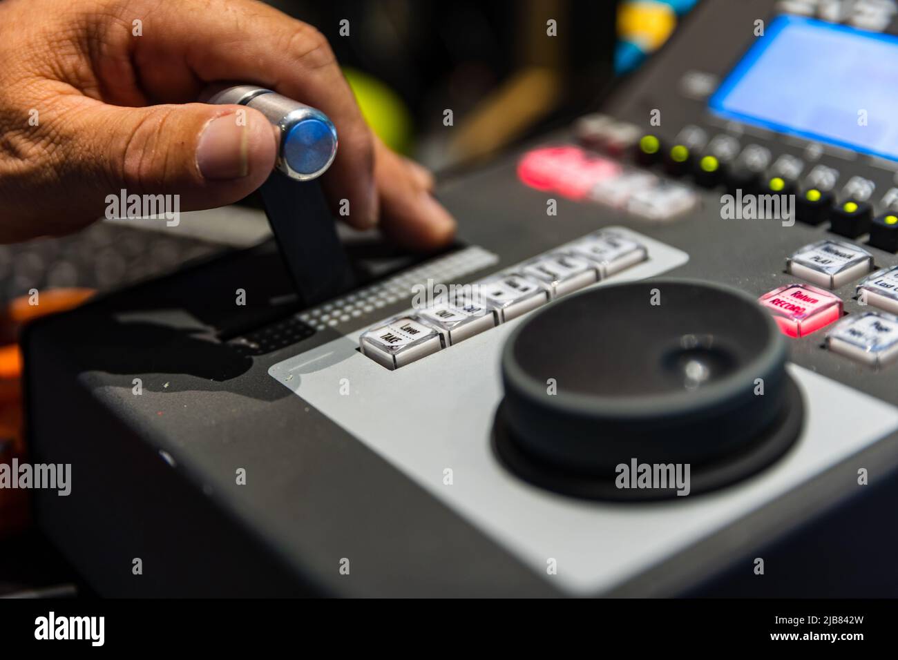 Operators hand controlling video replay for live broadcast event, shallow focus. Stock Photo