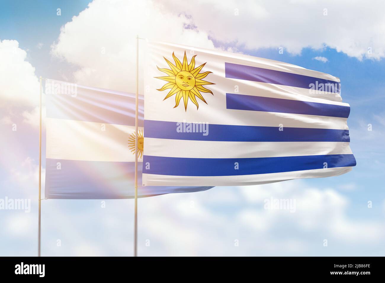 Sunny blue sky and flags of uruguay and argentina Stock Photo