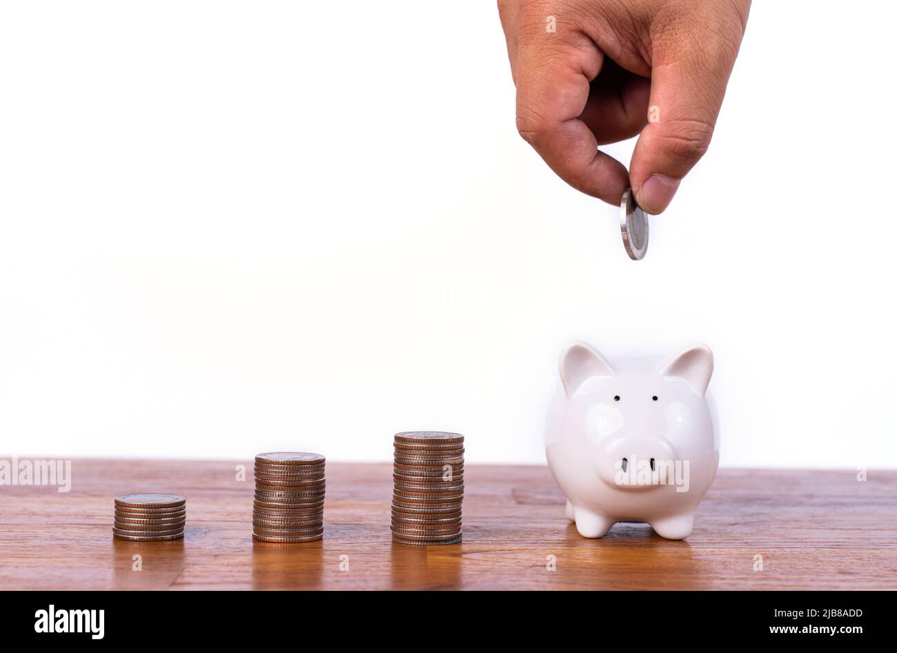 Hand putting coin to piggy bank with stack coin. Saving money and ...